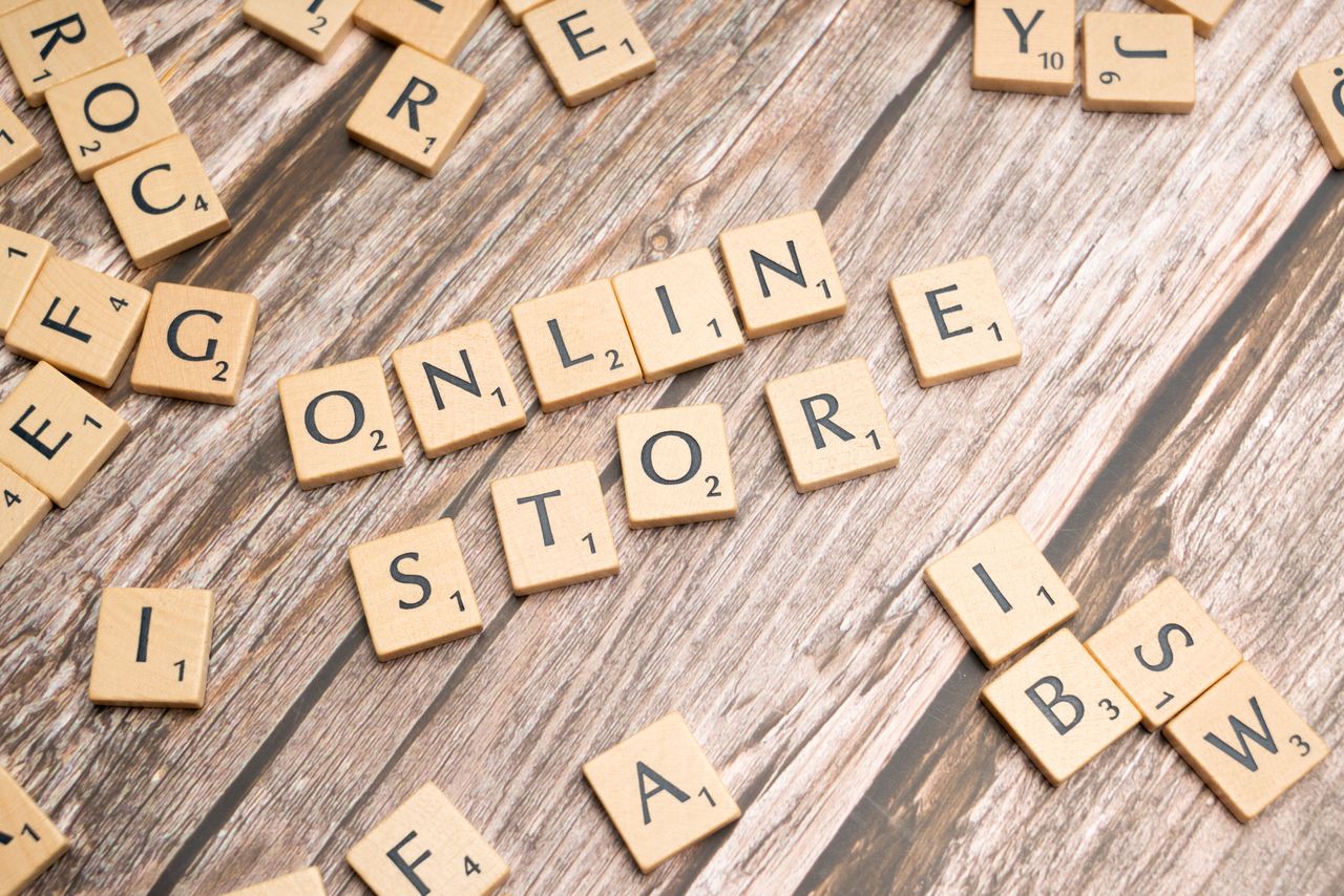 Home Scrabble tiles spelling 'online store' on a rustic wooden background.