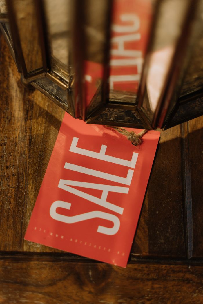 Home A red sale tag with bold white letters on a wooden surface, highlighting a Black Friday sale.